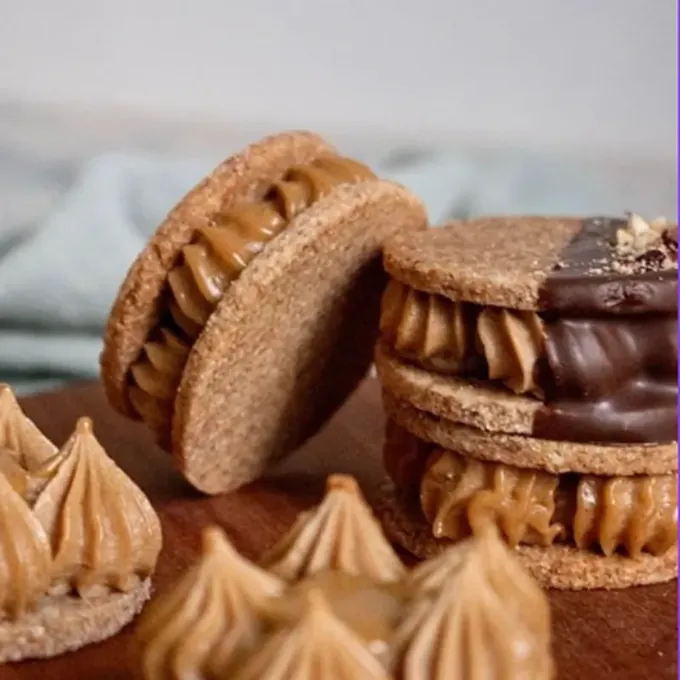 Hazelnut vegan alfajores with piped praline cream